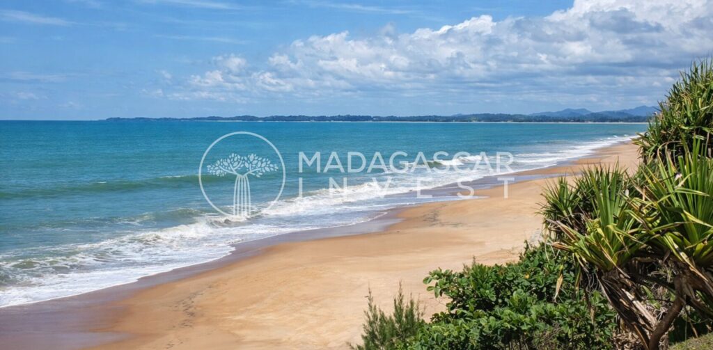 Image d'un terrain en bord de mer près de RFenerive Est montrant les vagues déferlant sur la plage avec le logo Madagascar Invest en filigrane