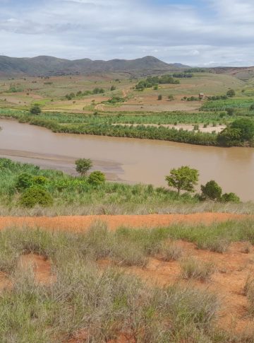 image showing a piece of madagascar farmland with a river flowing through it